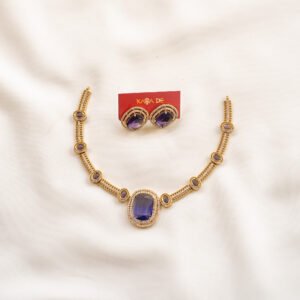 Gold necklace with deep violet stones and matching studs on ivory fabric – Karra De.
