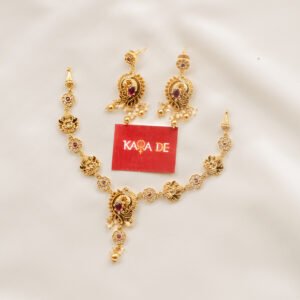 Antique gold necklace with ruby stones and peacock design held in hand – Karra De.
