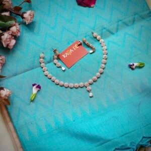 Floral diamond necklace set with teardrop accents on blue silk fabric – Karra De jewelry.