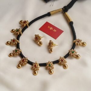 Black thread neckpiece with gold floral motifs and colorful stones – Karra De.